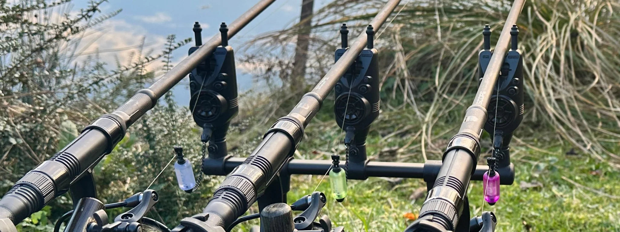 Trois détecteurs de touche sur rod pod avec balanciers colorés au bord de l'eau