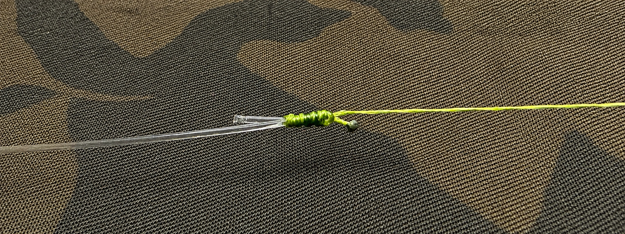 Nœud albright terminé reliant un arraché fluoro à un corps de ligne vert sur tapis camouflage