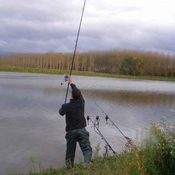 Carpiste exécutant un lancer longue distance avec canne à carpe action de pointe en bord de canal