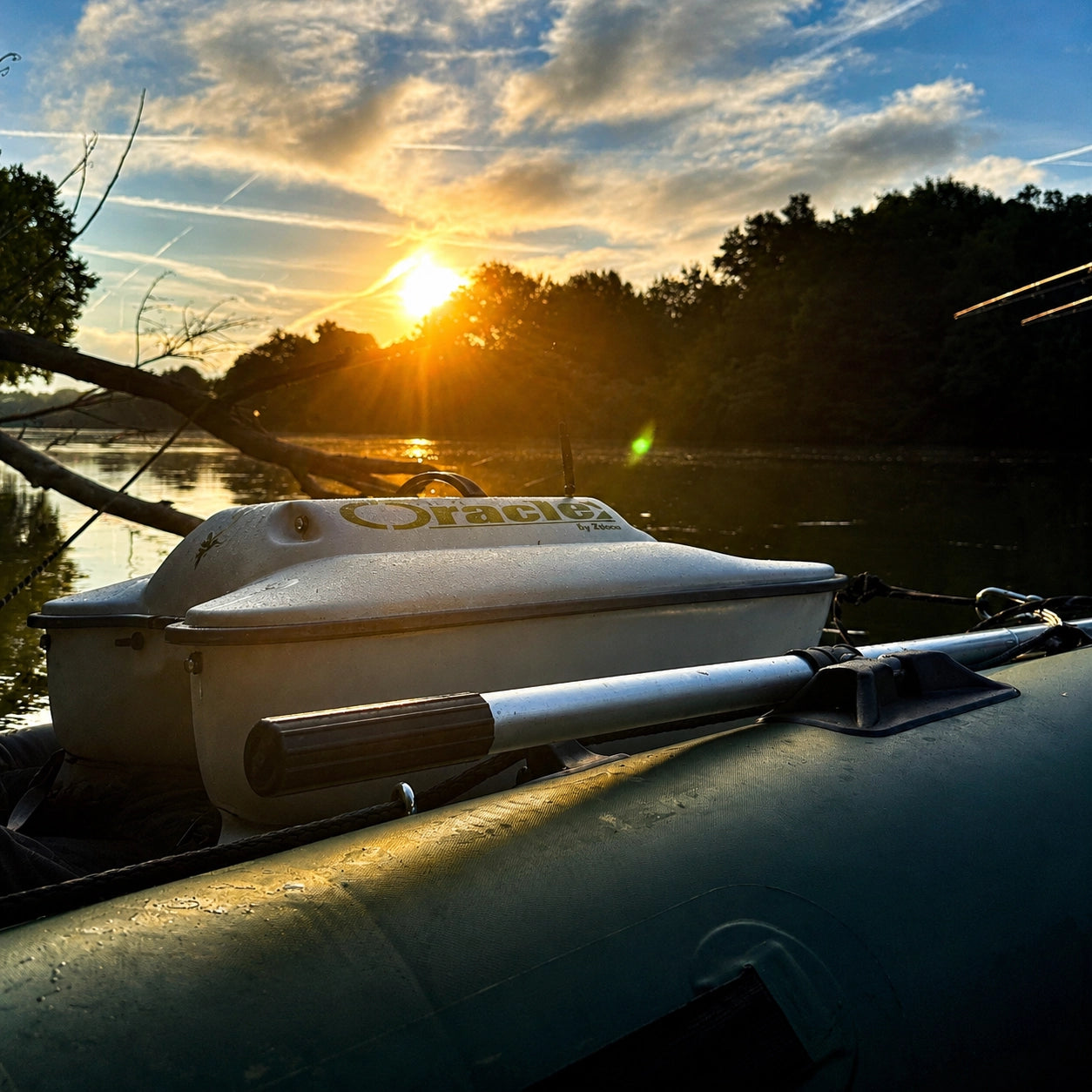 Bateau amorceur posé sur un bateau gonflable au coucher du soleil