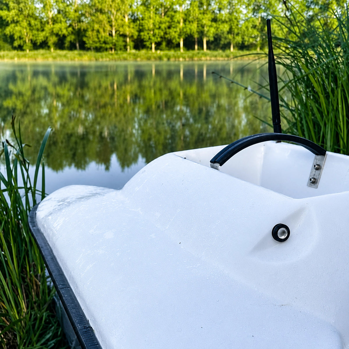 Bateau amorceur en bordure d'un plan d'eau pressionné, où les carpes deviennent méfiantes