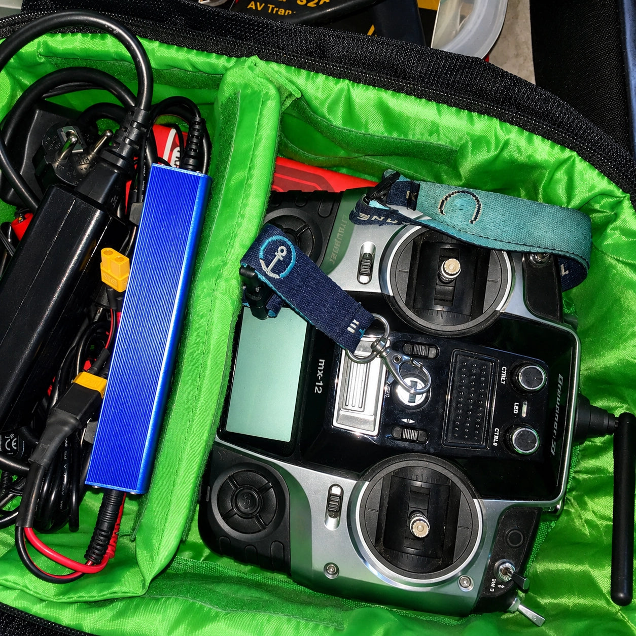 Télécommande, chargeur et batterie de bateau amorceur rangés dans un sac de transport