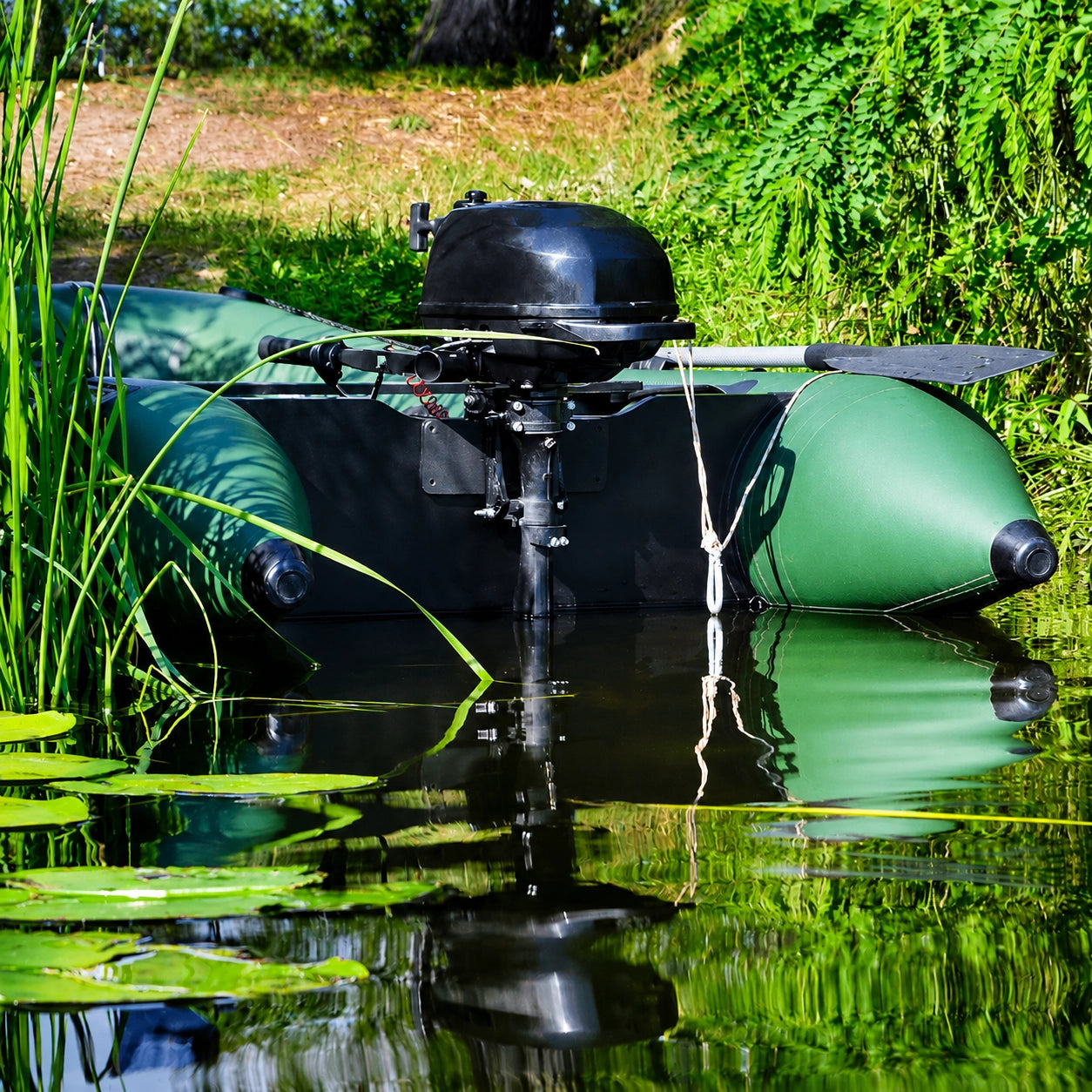 Bateau pneumatique motorisé électrique posé dans un étang à nénuphars