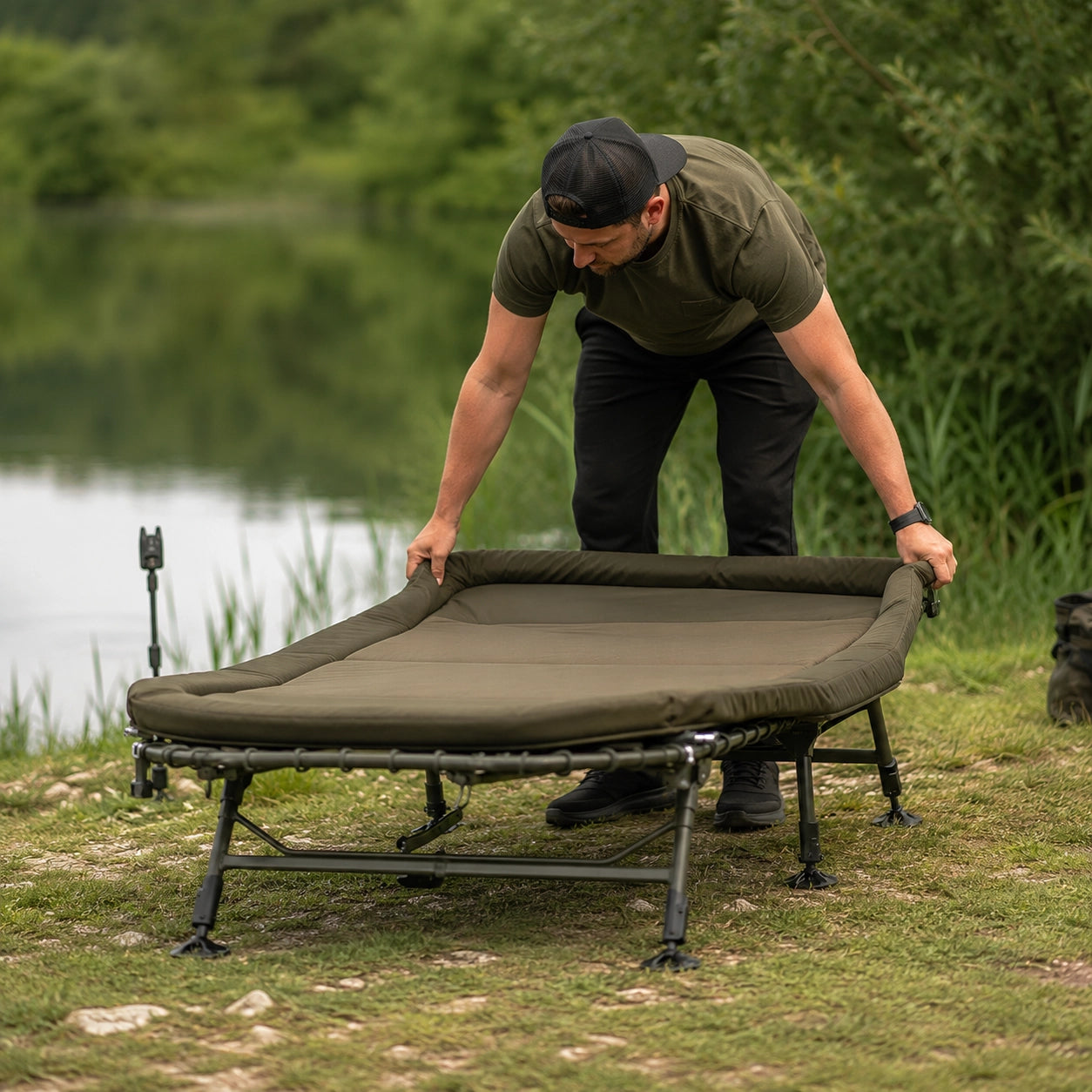 Dépliage d'un bedchair large au bord de l'eau avant l'installation du poste