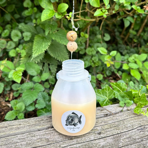 Booster Nutz+ à la noix tigrée présenté au bord de l'eau, additif liquide pour carpe