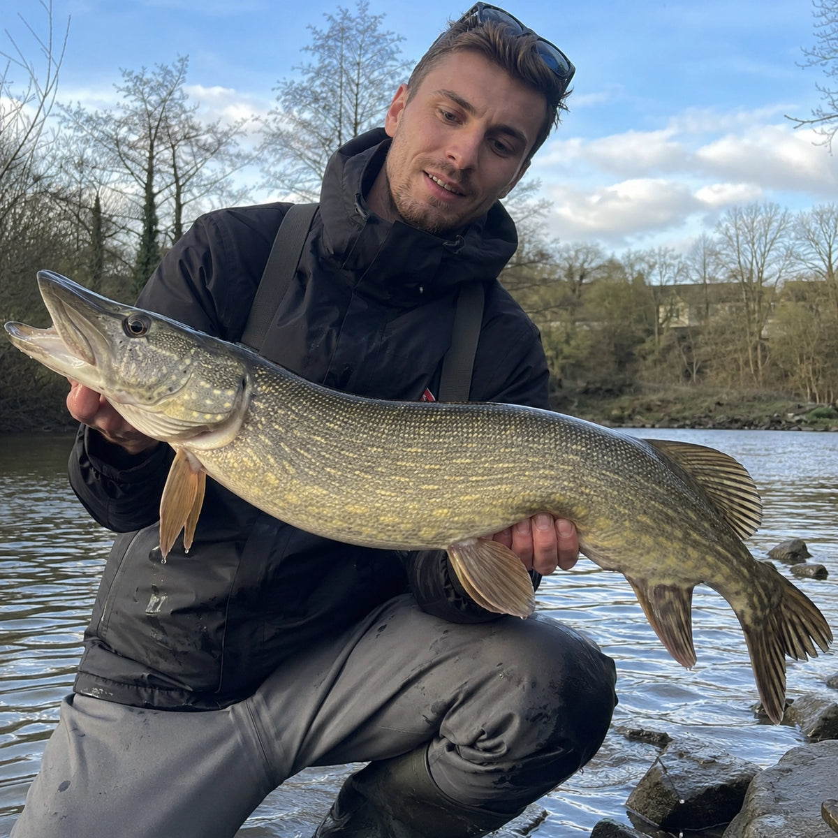 Pêcheur présentant un brochet, espèce ciblée sur les parcours carnassiers exclus de la carpe à toute heure