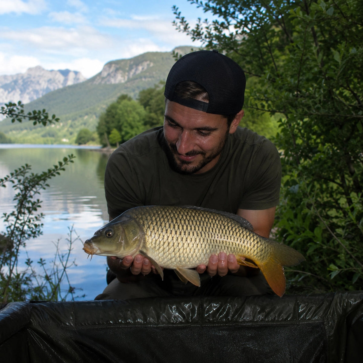 Carpiste présentant une carpe commune pêchée sur un lac des Alpes-de-Haute-Provence