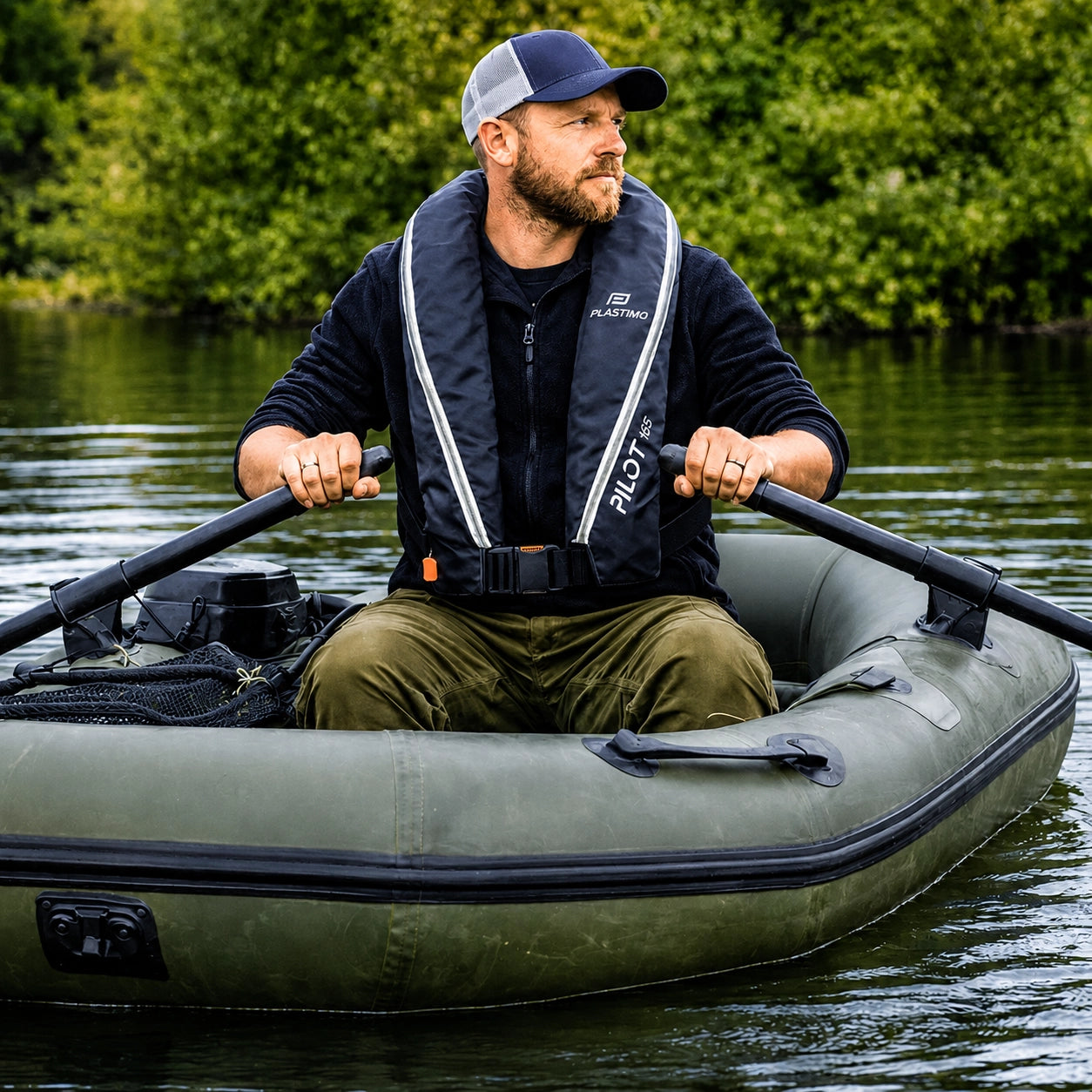 Pêcheur ramant en bateau pneumatique avec un gilet de sauvetage gonflable automatique