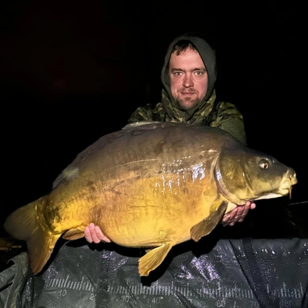Guillaume Desesquelles, fondateur de Magnifixcarp, présentant une carpe miroir capturée lors d'une session de nuit