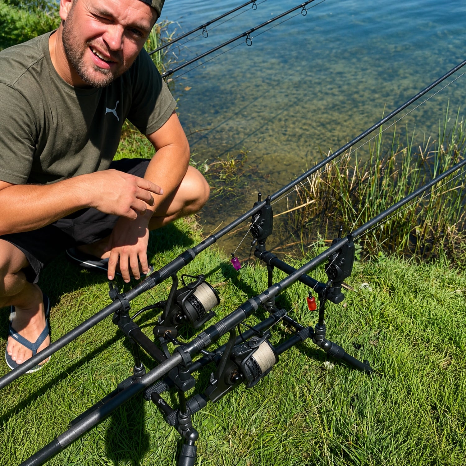 Pêcheur Magnifixcarp en session au bord de l'eau, deux cannes sur rod pod avec écureuils