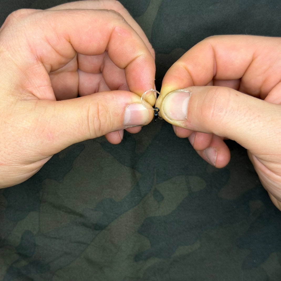 Nœud simple lâche formé avec le fil doublé, émerillon pendant dans la boucle, étape 3