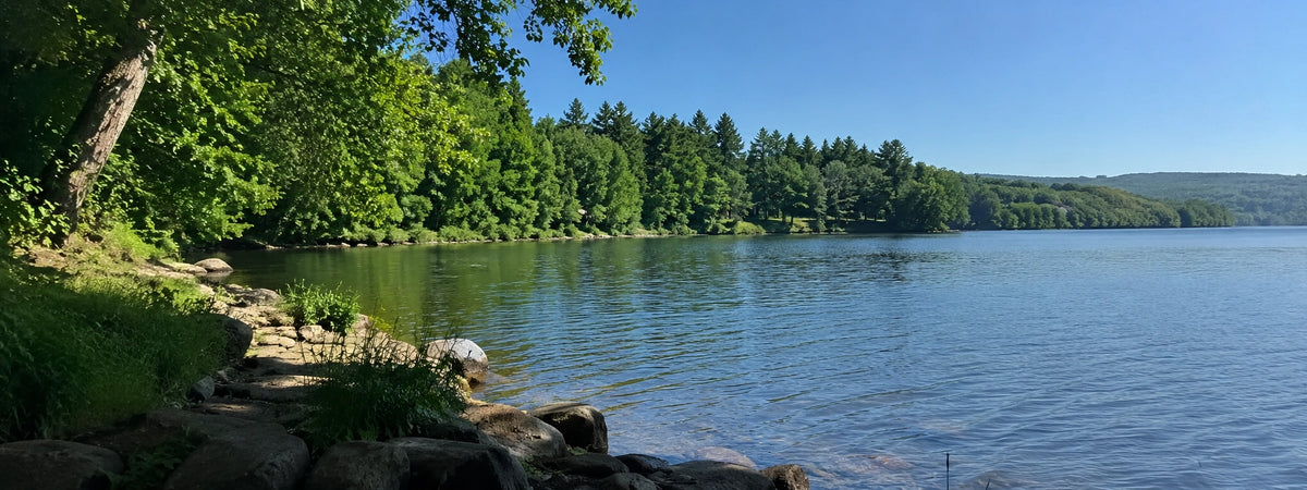 Lac de barrage aux berges rocheuses et boisées en Corrèze, terrain de pêche à la carpe