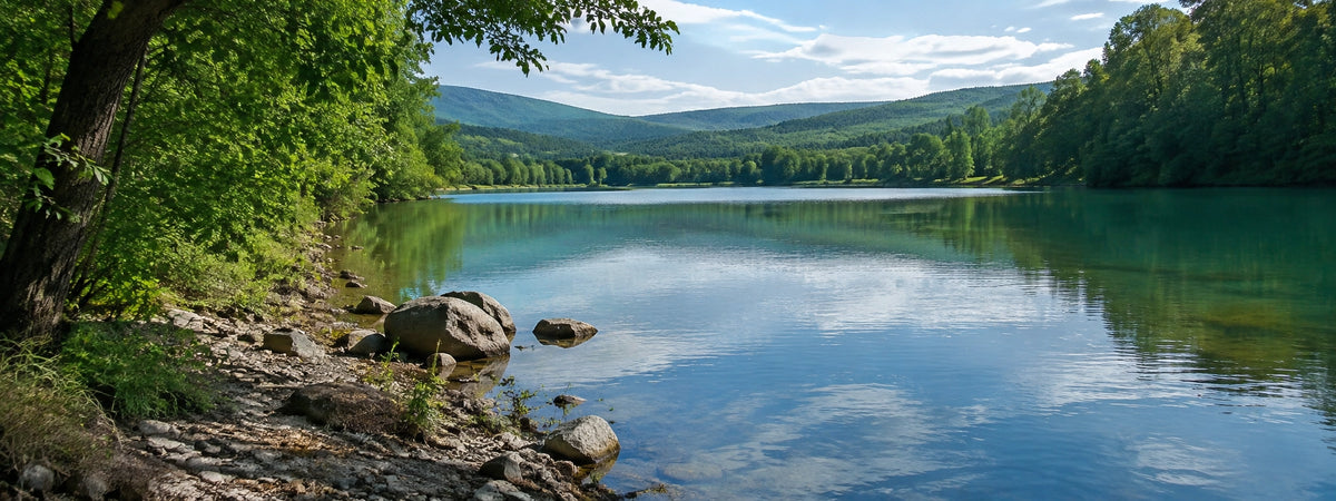 Plan d'eau calme bordé de collines boisées dans la vallée de la Drôme
