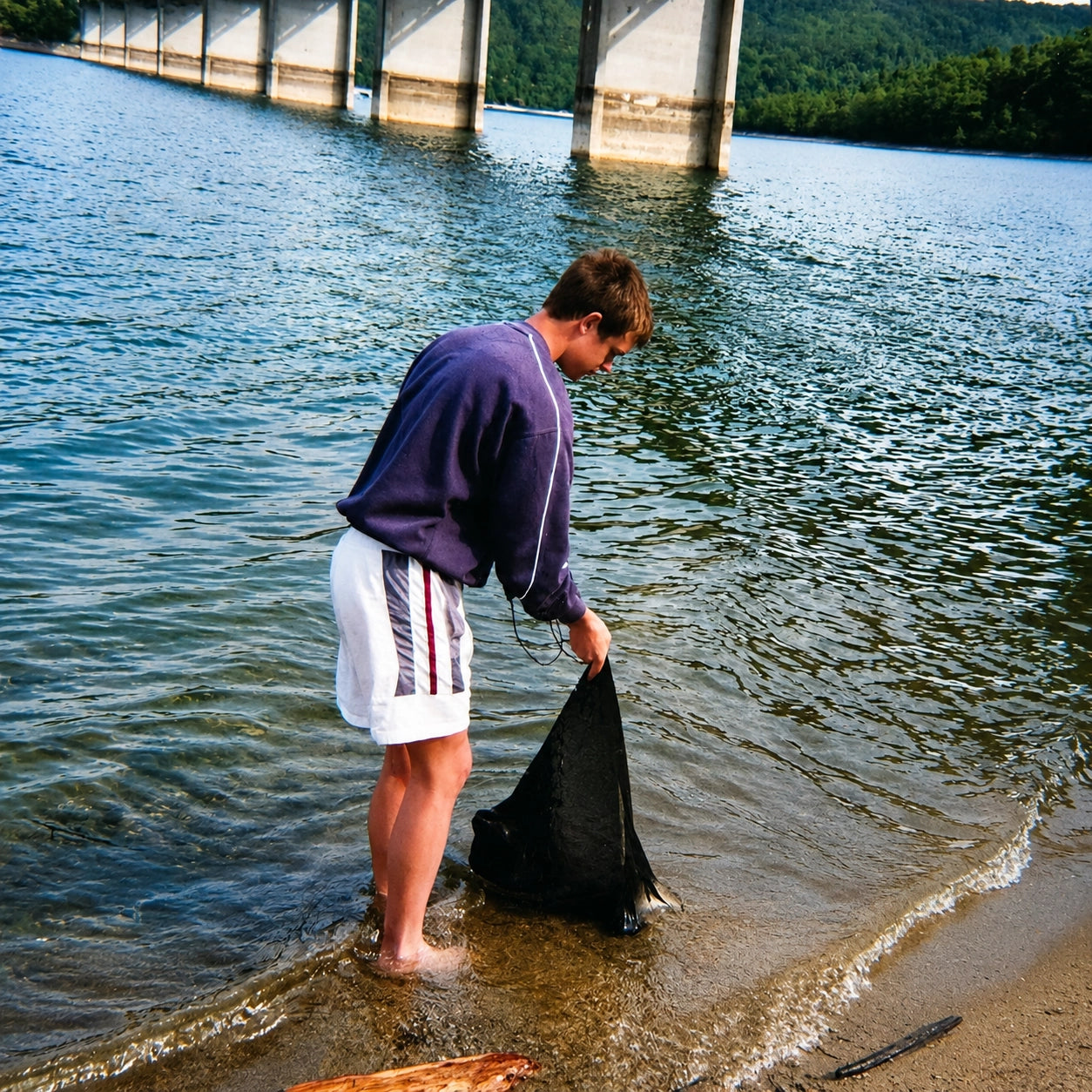 Carpiste manipulant son sac de conservation au bord du lac de Saint Cassien près du pont du bras nord