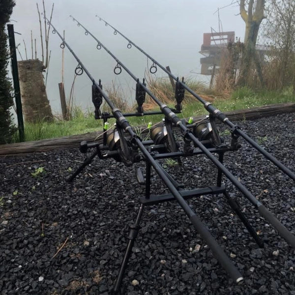 Trois cannes carpe posées sur un rod pod en bord de berge